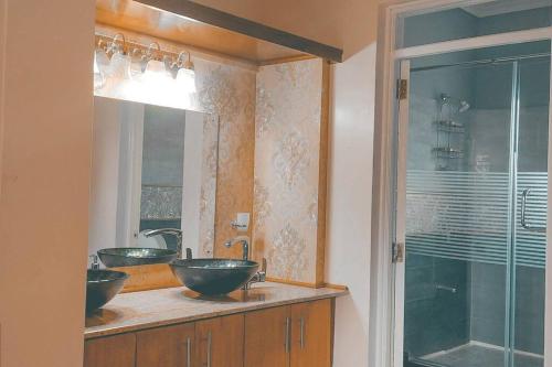 baño con 2 lavabos y ducha de cristal en LAIKIPIA WHITE HOUSE-NANYUKI, en Timau