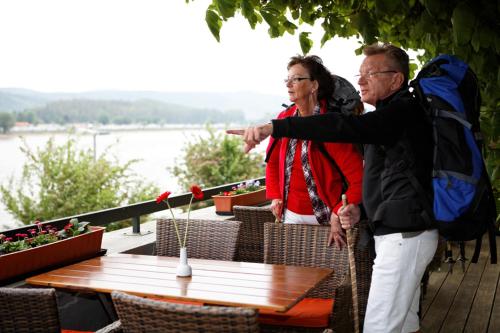 a man and a woman standing next to a table at Rheinhotel Vier Jahreszeiten Bad Breisig in Bad Breisig