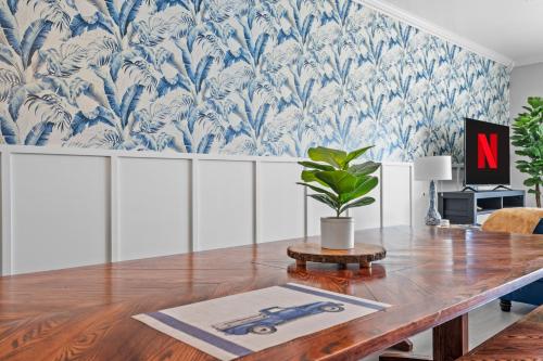 a dining room with a table and a blue and white wallpaper at ☆Live on the Water! Lake Palmetto Palm w/ Patio - 10Min to Downtown & Beaches☆ in Charleston