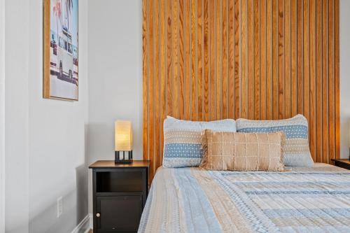 a bedroom with a bed with a wooden wall at ☆Live on the Water! Lake Palmetto Palm w/ Patio - 10Min to Downtown & Beaches☆ in Charleston