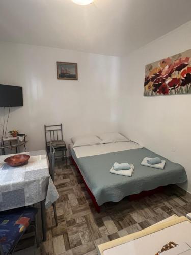 een kamer met twee bedden en een tafel en een televisie bij Hukic A2 And A1 in Fažana