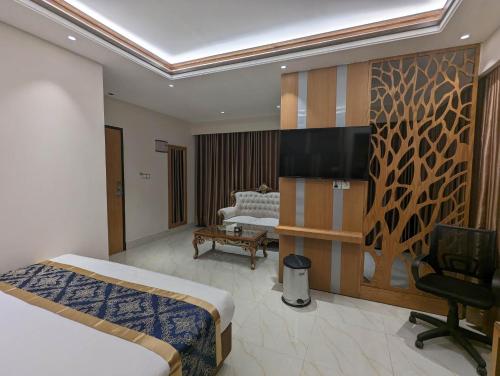 a hotel room with a bed and a tv on a wall at Hotel Royal Bengal in Dhaka