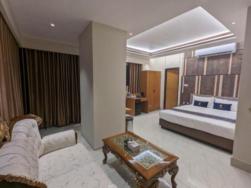 ダッカにあるHotel Royal Bengalのベッドとソファ付きのホテルルーム