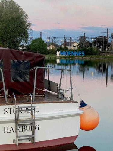 a boat sitting on a body of water at Le Nî’ De Jess in Migennes