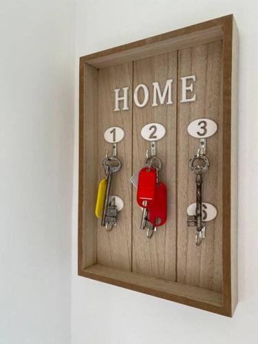 a wooden clock with the words home and keys at Le Nî’ De Jess in Migennes