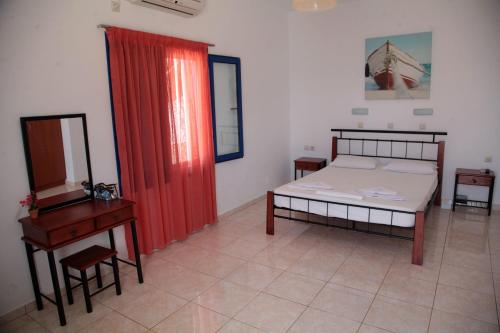 a bedroom with a bed and a table and a mirror at Paralia guest house in Agia Roumeli