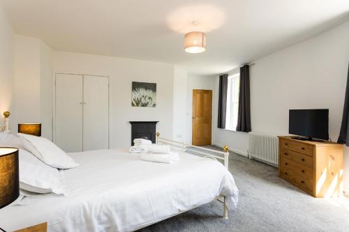 a bedroom with a bed and a flat screen tv at Algernon House in Alnwick