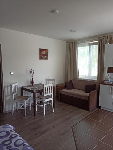 uma sala de estar com um sofá, uma mesa e cadeiras em Za Humnama em Hlohovec