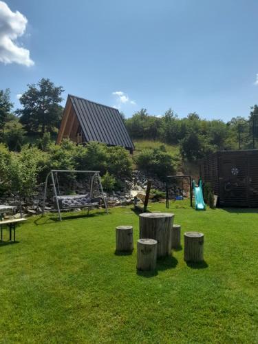 a park with a playground and some logs in the grass at Vila Miorita in Sebeş