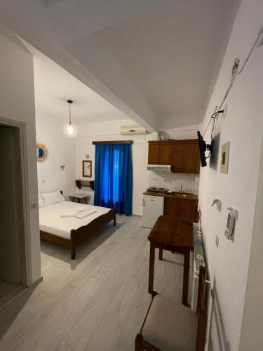 a room with a bed and a kitchen with a table at Delfinia Studios in Platanias