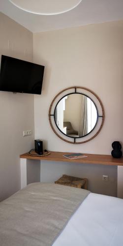 um quarto com um espelho redondo e uma cama em Lemonia Rooms em Platis Yialos Sifnos