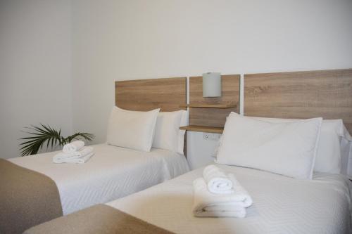 um quarto de hotel com duas camas com toalhas brancas em SIERRA LAGO em Córdoba