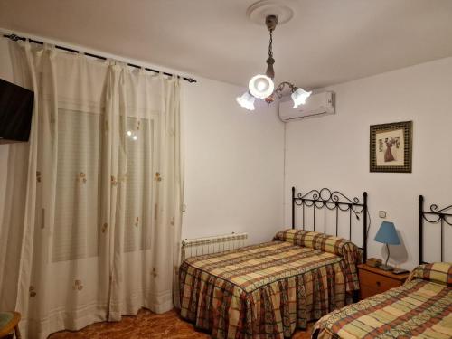 1 Schlafzimmer mit 2 Betten und einem Fenster in der Unterkunft Casa Rural La Malena in Cazalegas