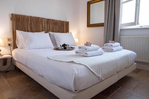 VátosにあるGuesthouse Elena , Vatos, Corfuのベッドルーム1室(白いベッド1台、タオル付)