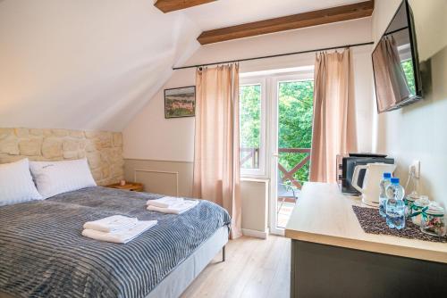 ein Schlafzimmer mit einem Bett und eine Küche mit einem Fenster in der Unterkunft Góry i Doliny in Kazimierz Dolny