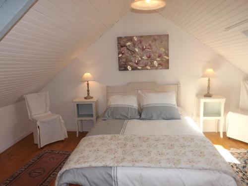 1 dormitorio con 1 cama y 2 sillas en el ático en GITE RURAL FINISTERE SUD ENTREE PRESQUI'LE CROZON, en Saint-Ségal