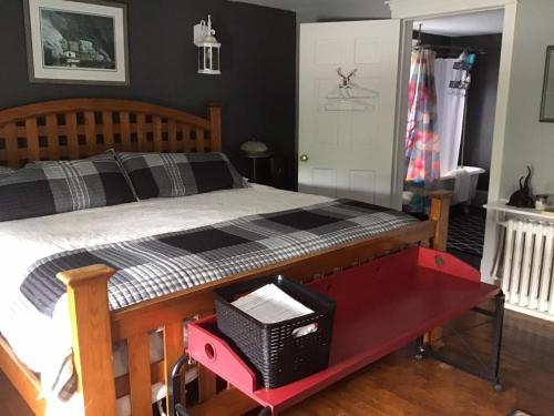 Little Bras dʼOr的住宿－Celtic Mansion Annfield Manor，一间卧室配有一张大床和一张红色桌子