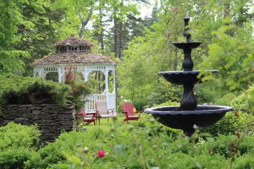 a fountain in a garden with a gazebo at Celtic Mansion Annfield Manor in Little Bras dʼOr
