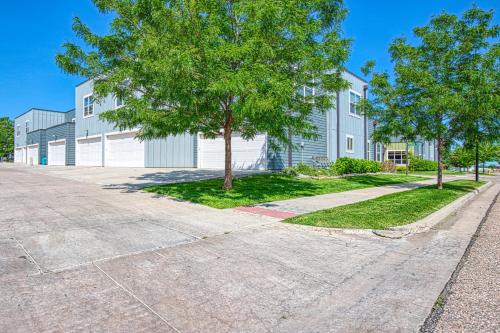 an empty street in front of a building with trees at Modern Townhome near Old Town, Breweries, & River! in Fort Collins