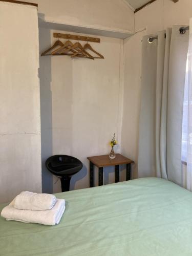 una camera con un letto verde e un tavolo di Hostal Centro Pucón B a Pucón