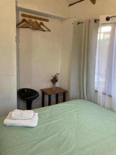 una camera da letto con un letto e un asciugamano sopra di Hostal Centro Pucón B a Pucón