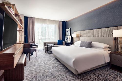 um quarto de hotel com uma cama e uma televisão de ecrã plano em JW Marriott Hotel Monterrey Valle em Monterrey