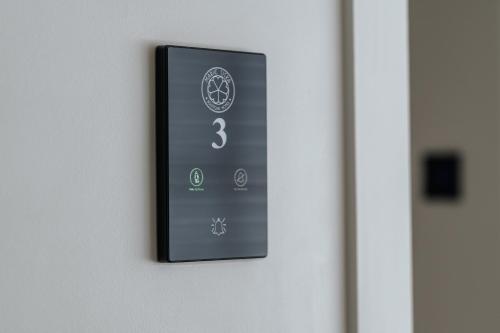 a lightswitch on a wall with the number three on it at Marie Siska Boutique hotel in Knokke-Heist
