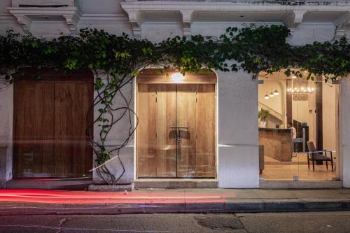 a large wooden door on a building with a table at Soy Local Insignia in Cartagena de Indias