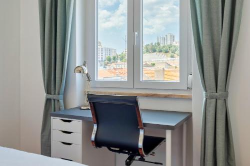 - un bureau avec une chaise devant une fenêtre dans l'établissement Castle View, à Setúbal