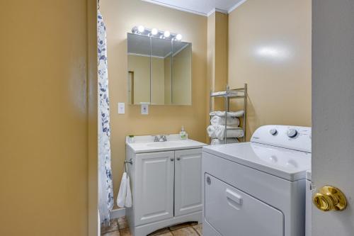 a bathroom with a sink and a washing machine at Cozy Home with Backyard about 3 Mi to Downtown Saginaw! in Saginaw