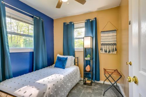a small bedroom with blue curtains and a bed at Cozy Home with Backyard about 3 Mi to Downtown Saginaw! in Saginaw