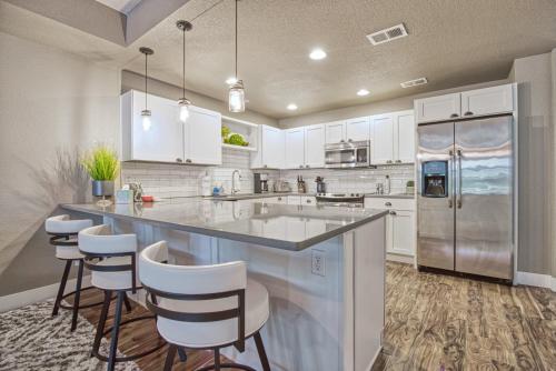 a kitchen with white cabinets and a large island with bar stools at 2 Bedroom townhome, super close to downtown FC! in Fort Collins