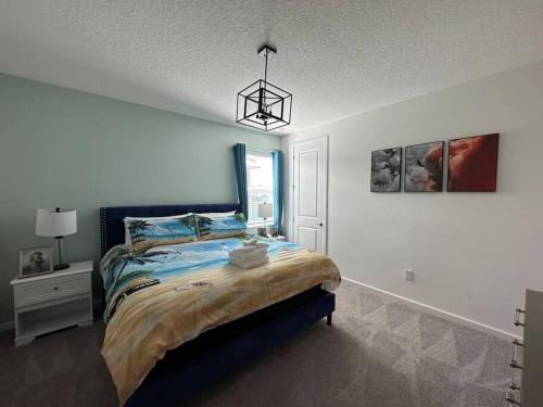 a bedroom with a bed and a chandelier at ☀️12BR Disney Villa Paradise w/ Game Room & Pool/Spa☀️ in Kissimmee