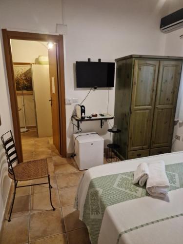 1 dormitorio con cama, mesa y TV en Agriturismo Su Recreu, en Ittiri