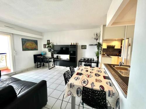 une cuisine et un salon avec une table et un canapé dans l'établissement Super t 3, vue mer piscine clim, au Barcarès