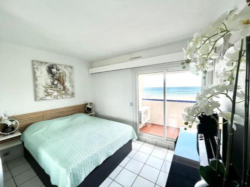 une chambre avec un lit et une vue sur l'océan dans l'établissement Super t 3, vue mer piscine clim, au Barcarès