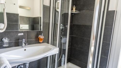 a bathroom with a sink and a shower at Hotel Europe Brig in Brig