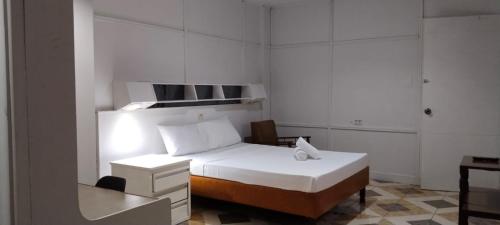 a white bedroom with a bed and a desk at 2 Hotel Saleh in Angeles