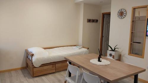 1 dormitorio con cama, mesa, mesa y sillas en V&Malojamiento en Ushuaia