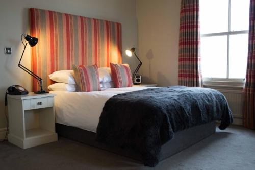 a bedroom with a bed with a blanket on it at The Pier Hotel in Harwich