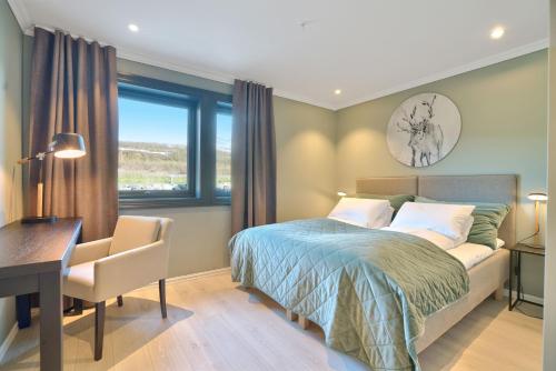1 dormitorio con cama, escritorio y ventana en Lyngen Experience Lodge, en Nord-Lenangen