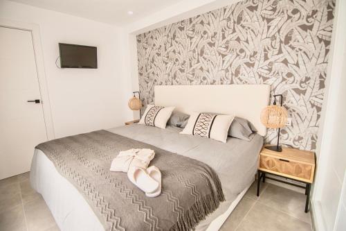 a bedroom with a bed with white shoes on it at Amazing Old Town Penthouse II - EaW Homes in Marbella