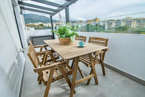 a wooden table and chairs on a balcony at Amazing Old Town Penthouse II - EaW Homes in Marbella