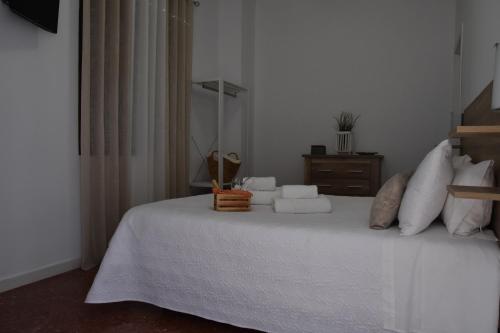 a bedroom with a bed with white sheets and pillows at SIERRA LAGO in Córdoba