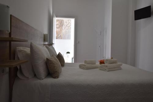 a white bed with white pillows and towels on it at SIERRA LAGO in Córdoba