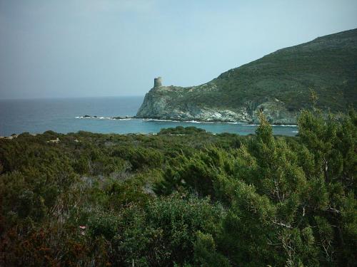 a lighthouse on a small island in the ocean at Hôtel U Pozzu in Sisco