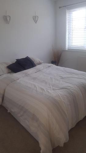 uma grande cama branca num quarto com uma janela em 31 riverside em Great Clifton