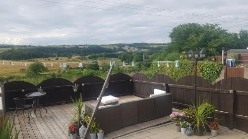 a patio with a bench and a table on a fence at 31 riverside in Great Clifton