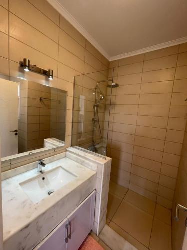 a bathroom with a sink and a shower and a mirror at Almaza Bay Beach Town Chalet in Marsa Matruh