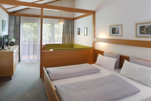 1 dormitorio con 2 camas y bañera en Appartement-Hotel Happy Kienberg, en Pfronten